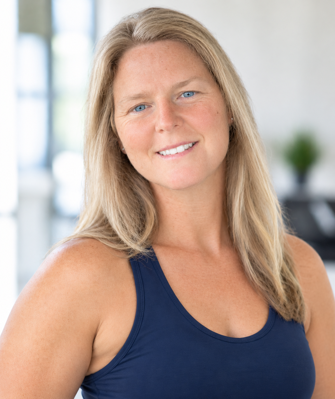 Amy, personal trainer and wellness coach, smiling in a bright studio